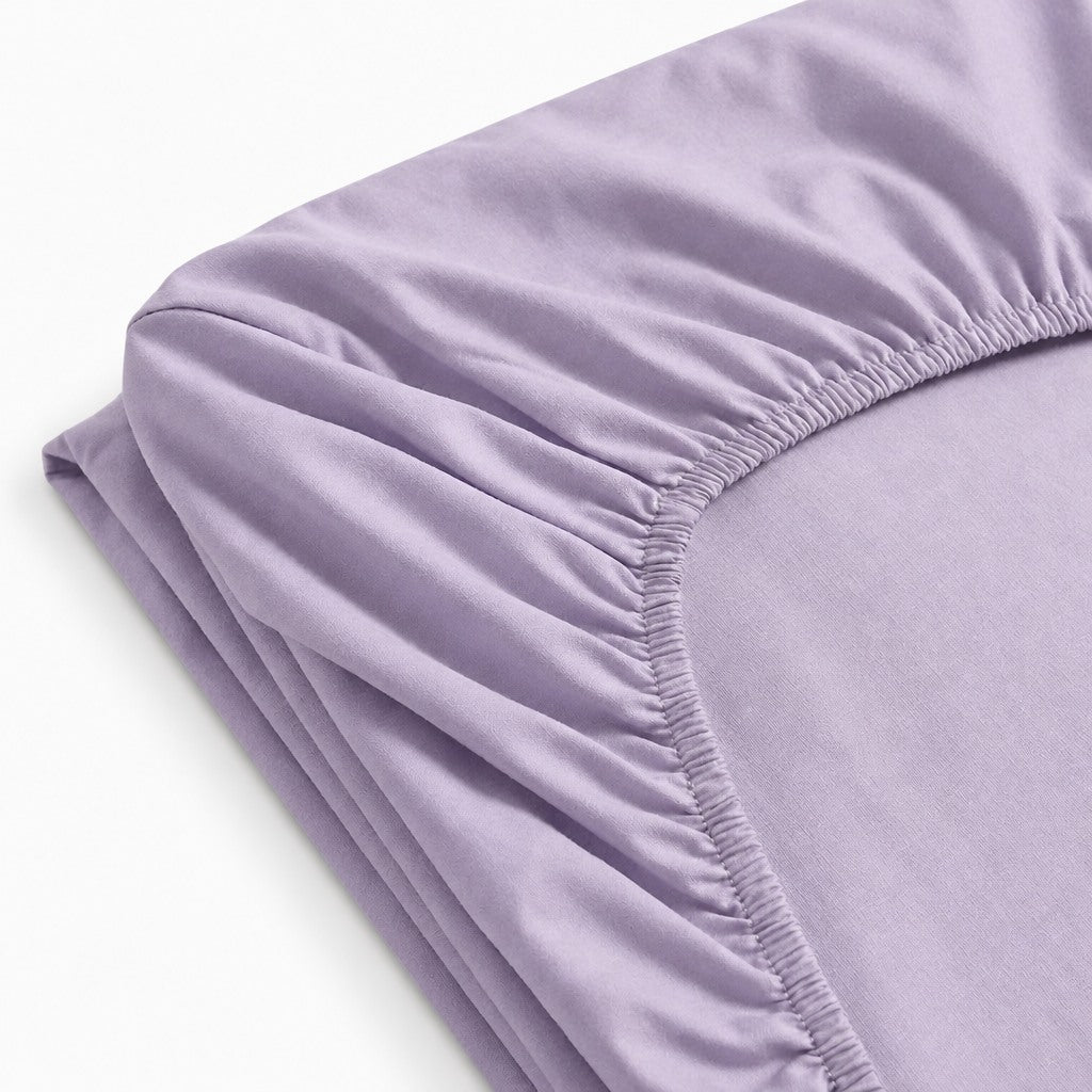 Drap-housse 100 % coton jersey blanc, extensible et doux, ajusté sur un matelas.