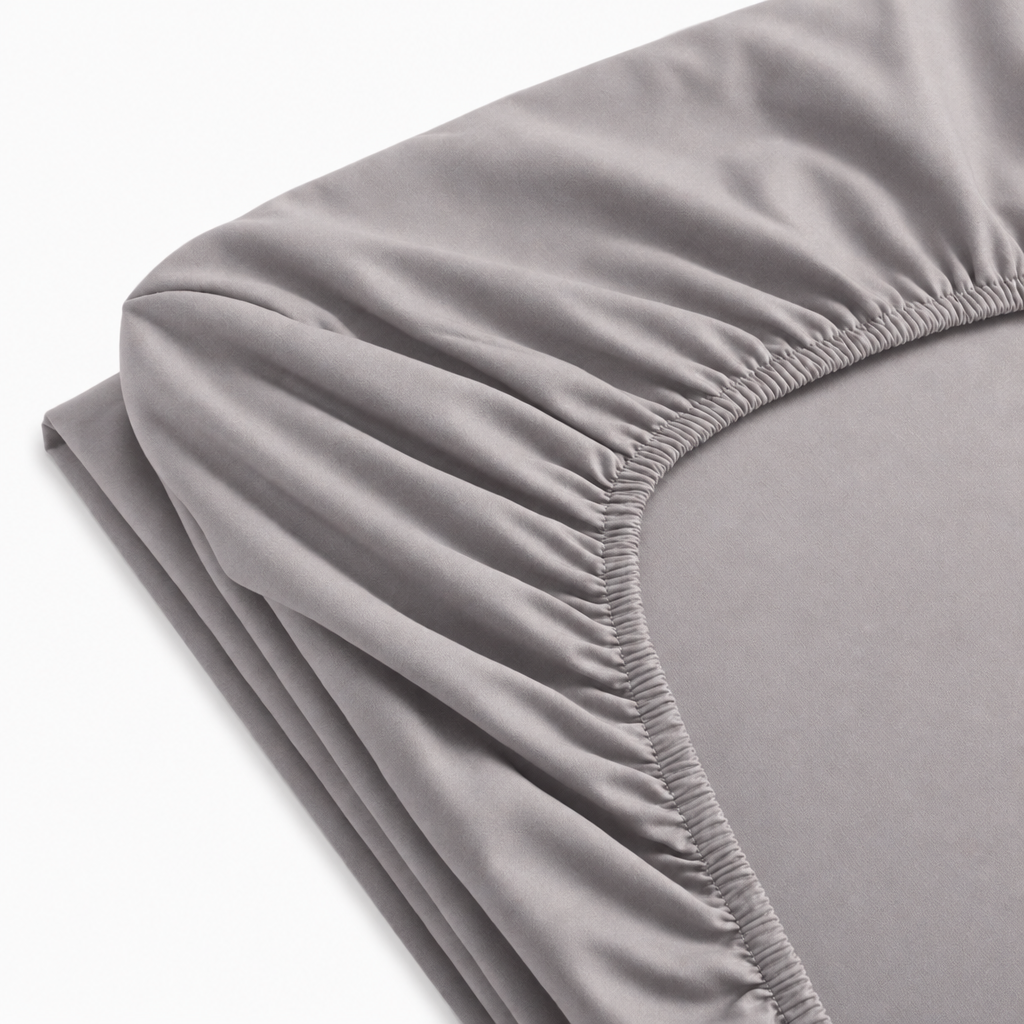 Drap-housse en percale de coton blanc, tissu lisse et respirant avec élastique pour maintien optimal sur matelas.