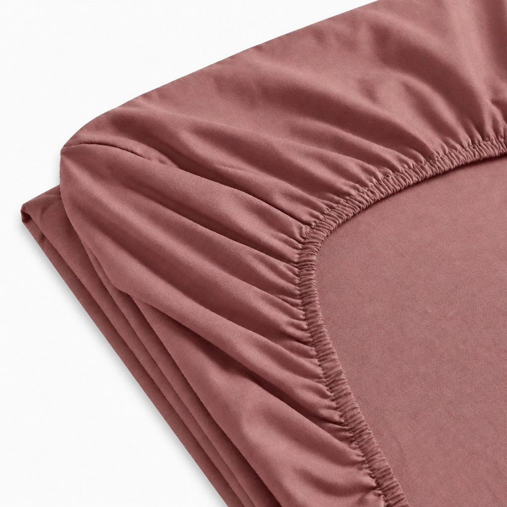 Drap-housse en percale de coton uni, texture lisse et respirante, maintien optimal avec élastique, confection européenne de qualité supérieure.