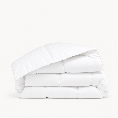 Couette satin premium blanche en satin de coton, à rayures discrètes et piquage en carreaux cloisonnés enveloppants.